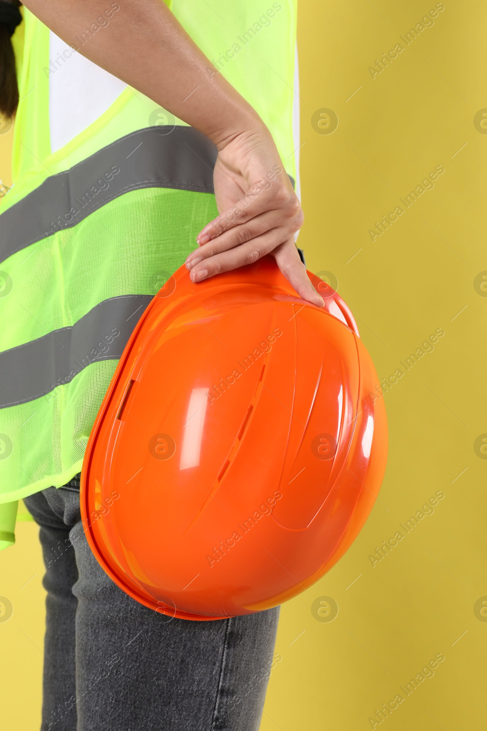 Photo of Engineer with hard hat on yellow background, closeup