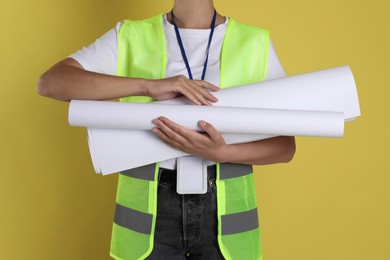 Photo of Engineer with drafts on yellow background, closeup