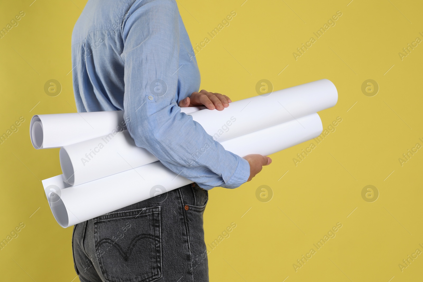 Photo of Engineer with drafts on yellow background, closeup