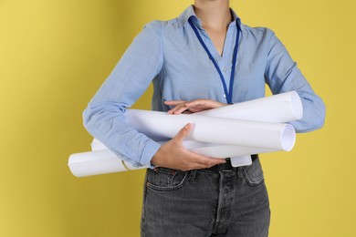 Photo of Engineer with drafts on yellow background, closeup