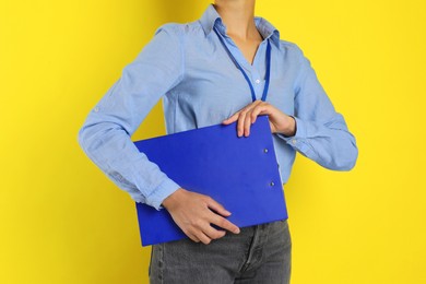 Photo of Engineer with clipboard on yellow background, closeup