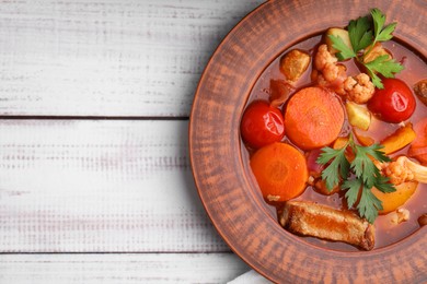 Tasty homemade stew with vegetables on white wooden table, top view. Space for text