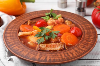 Photo of Tasty homemade stew with vegetables on white wooden table, closeup