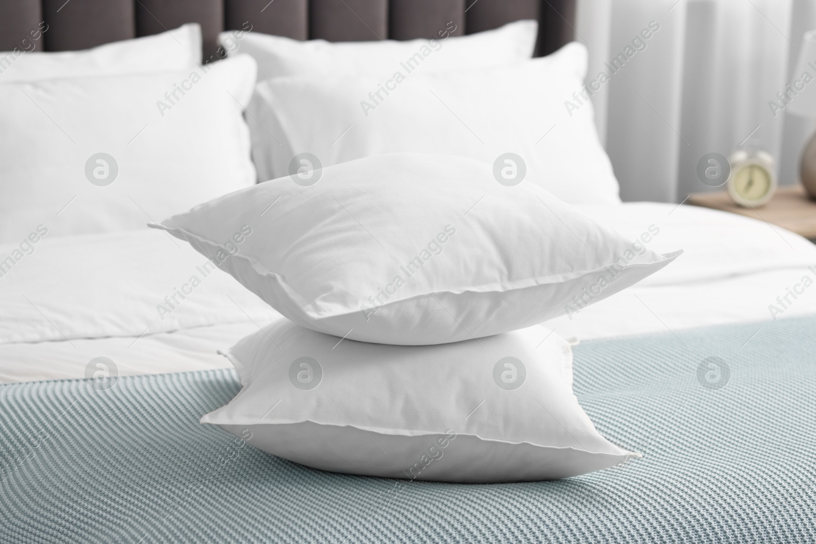 Photo of Many soft pillows on bed at home