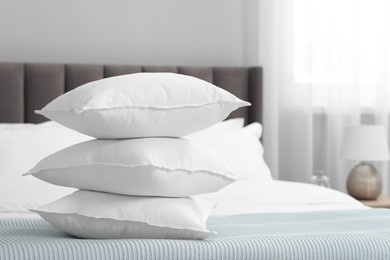 Photo of Many soft pillows on bed at home