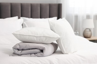 Soft pillows and duvet on bed at home