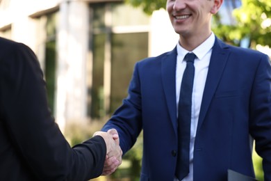 Photo of Diplomats shaking hands during meeting outdoors, closeup