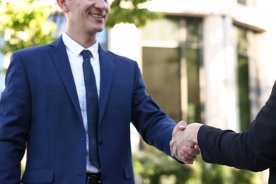 Photo of Diplomats shaking hands during meeting outdoors, closeup