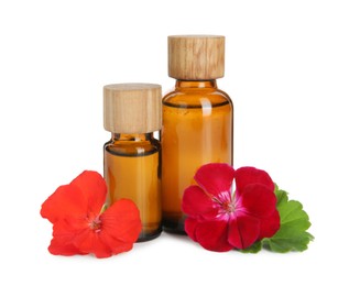 Photo of Bottles of geranium essential oil and beautiful flowers isolated on white