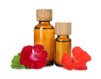 Photo of Bottles of geranium essential oil and beautiful flowers isolated on white