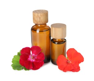 Bottles of geranium essential oil and beautiful flowers isolated on white