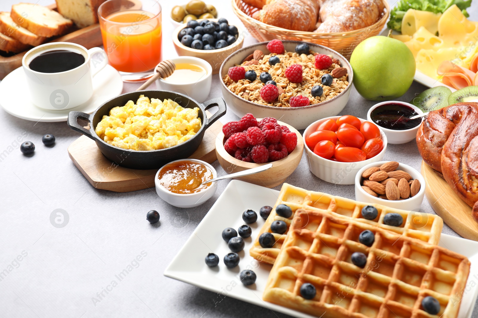 Photo of Tasty breakfast. Many different food and drinks on grey textured table, closeup