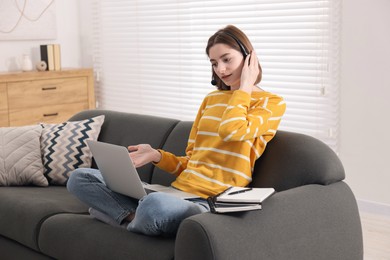 Teenager in headset having video chat via laptop at home. Remote work