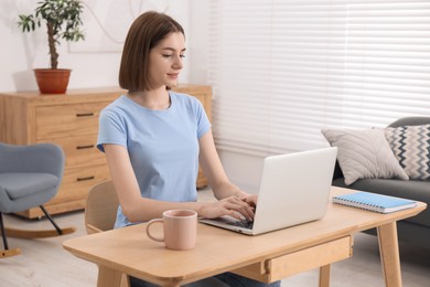 Teenager working with laptop at home. Remote job