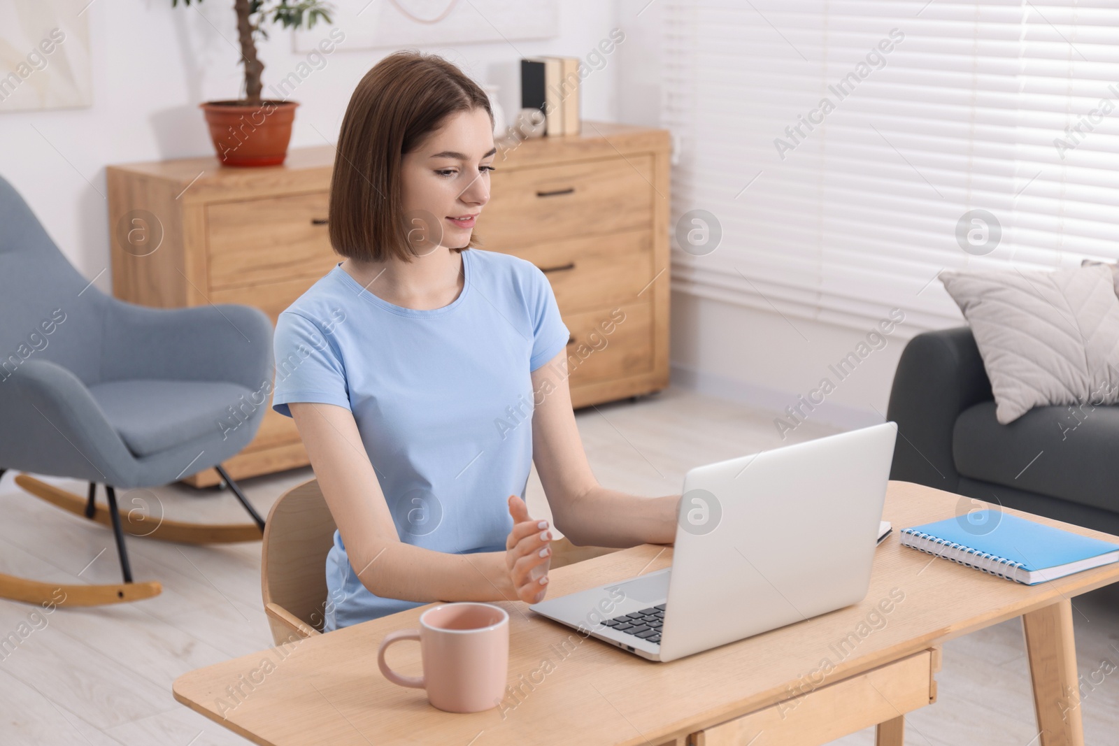 Photo of Teenager having video chat via laptop at home. Remote work