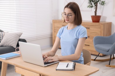 Teenager working with laptop at home. Remote job