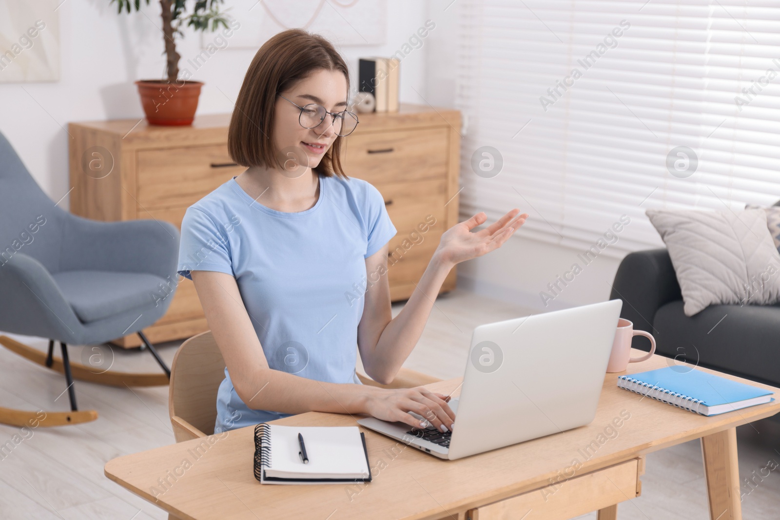 Photo of Teenager having video chat via laptop at home. Remote work