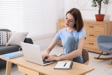 Teenager working with laptop at home. Remote job