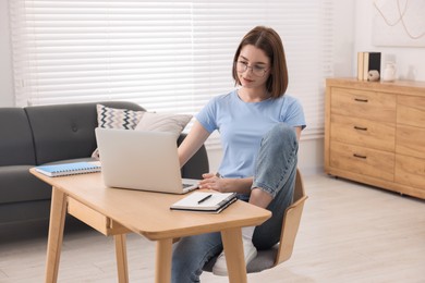 Teenager working with laptop at home. Remote job