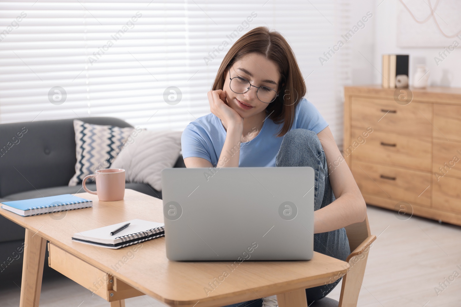 Photo of Teenager working with laptop at home. Remote job