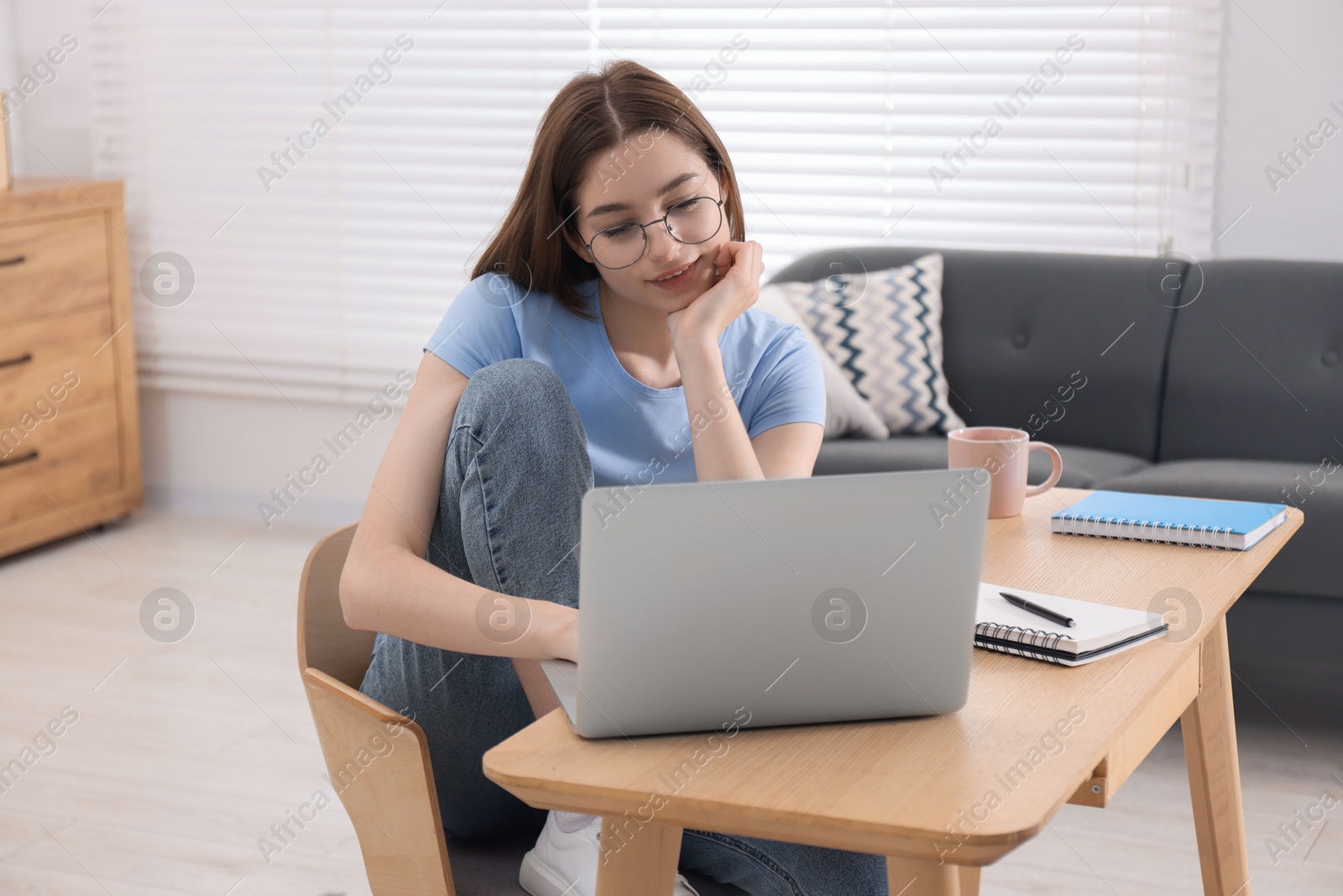 Photo of Teenager working with laptop at home. Remote job