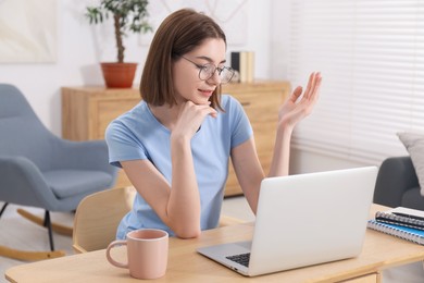 Photo of Teenager having video chat via laptop at home. Remote work