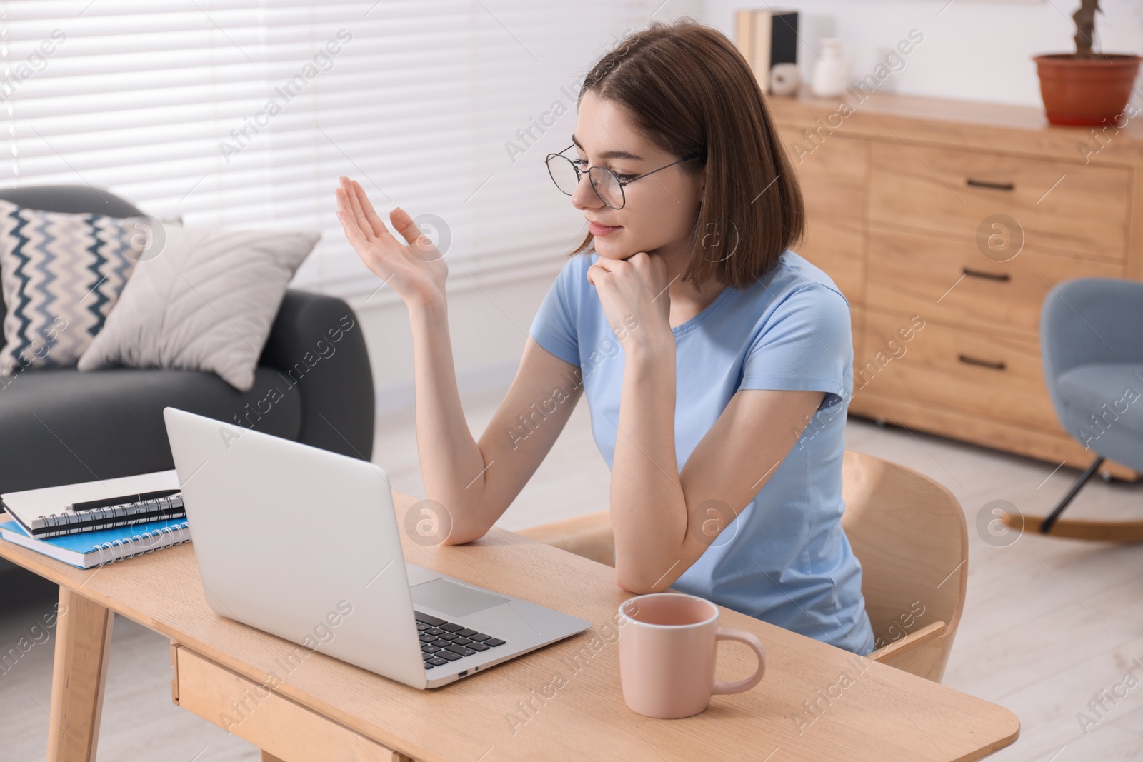 Photo of Teenager having video chat via laptop at home. Remote work