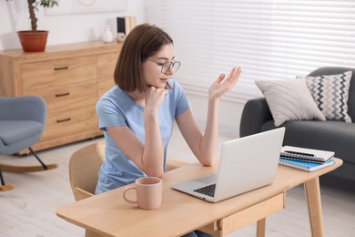 Teenager having video chat via laptop at home. Remote work