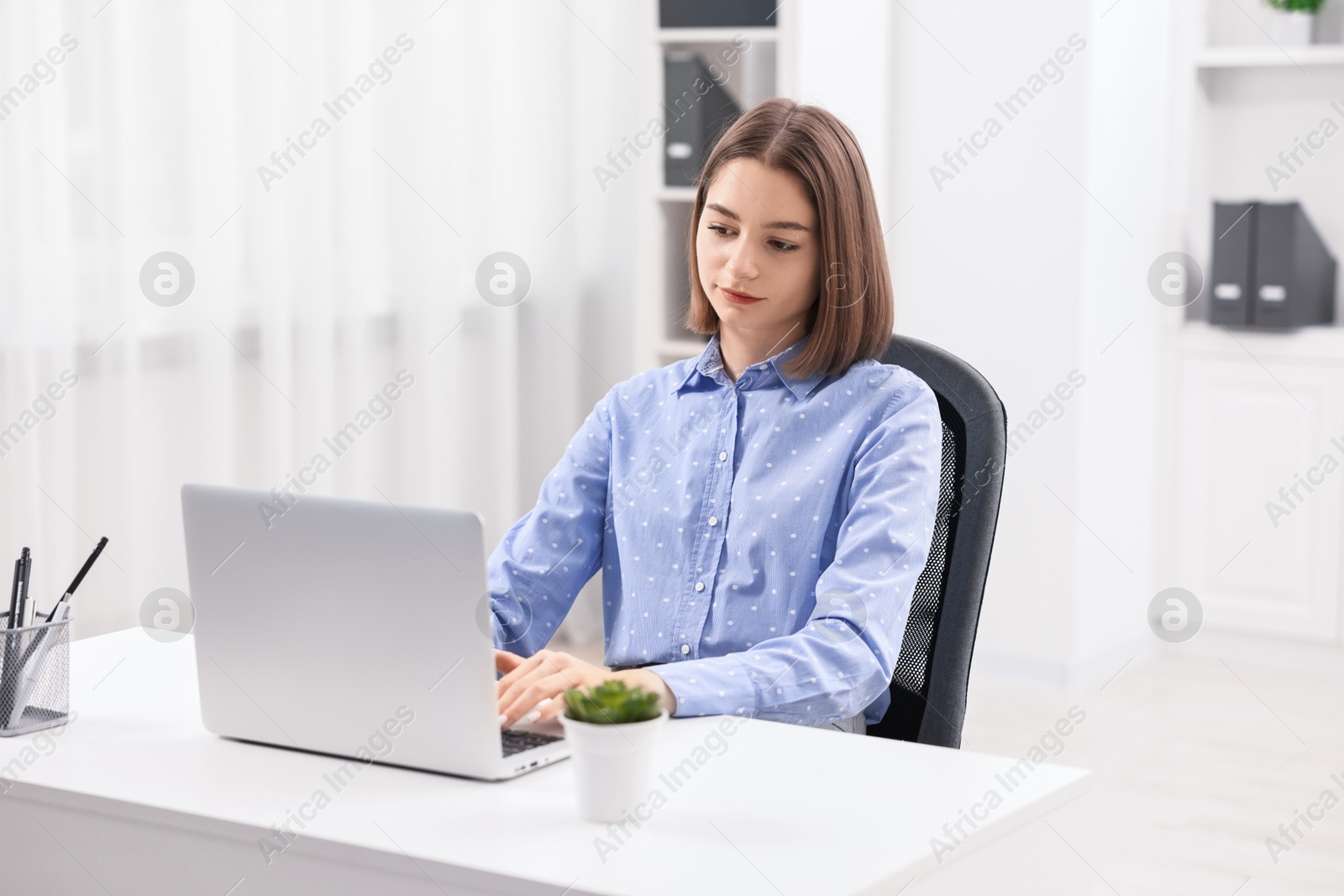 Photo of Teenager working with laptop at home. Remote job