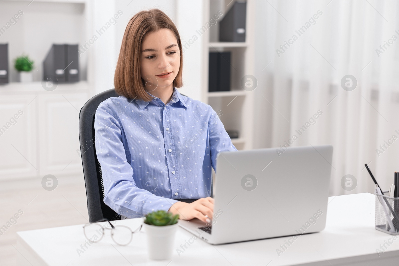 Photo of Teenager working with laptop at home. Remote job