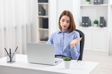 Photo of Teenager having video chat via laptop at home. Remote work