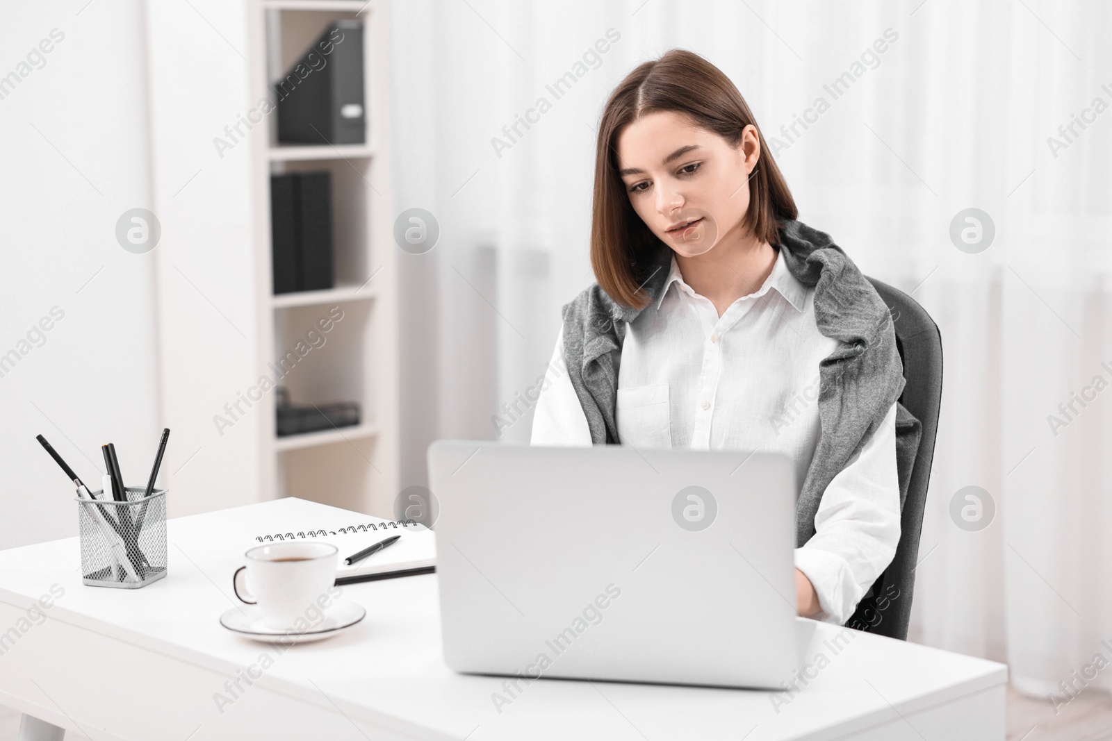 Photo of Teenager working with laptop at home. Remote job