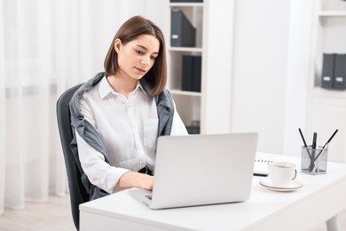 Teenager working with laptop at home. Remote job