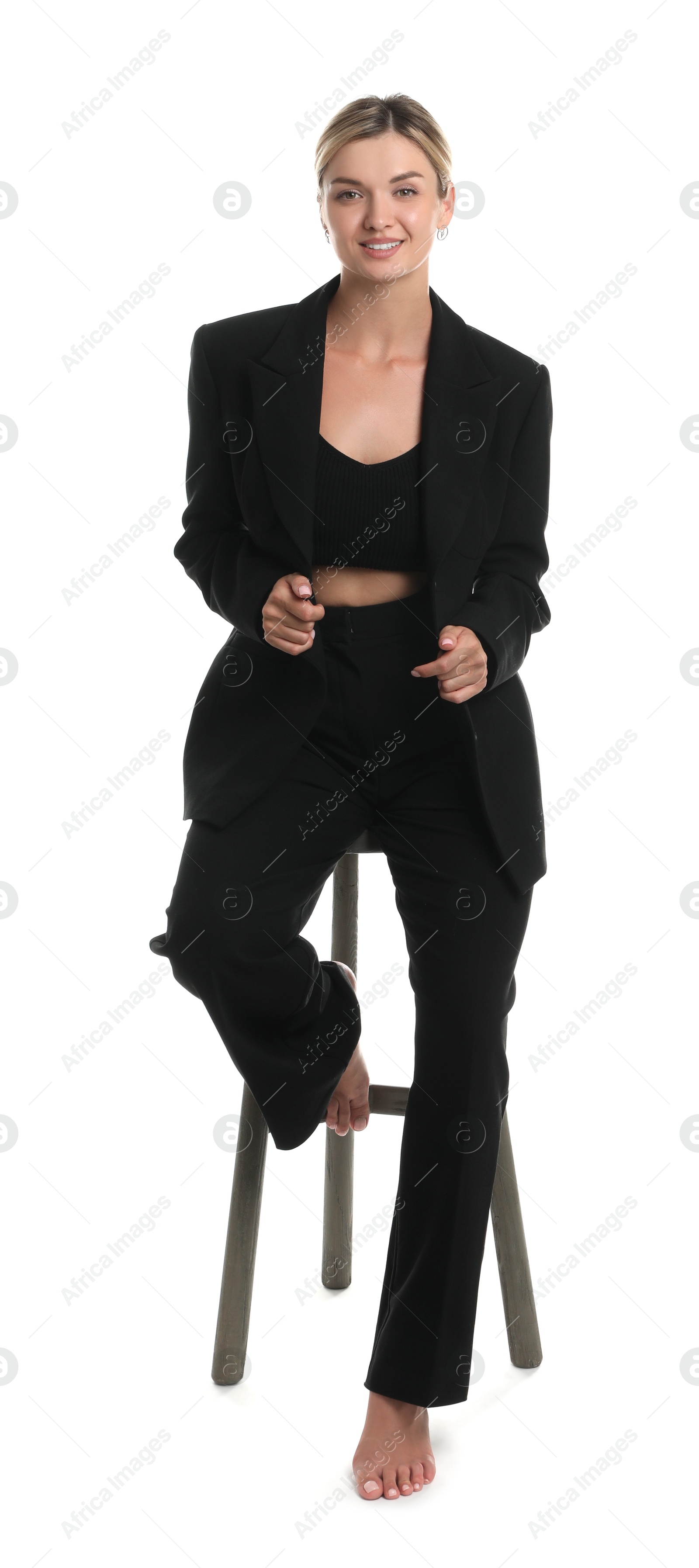 Photo of Beautiful woman in stylish suit on stool against white background