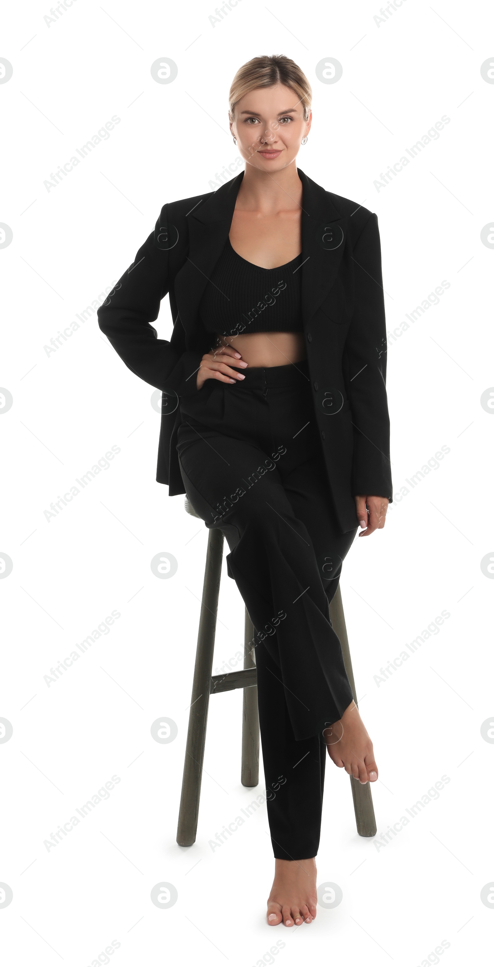 Photo of Beautiful woman in stylish suit on stool against white background