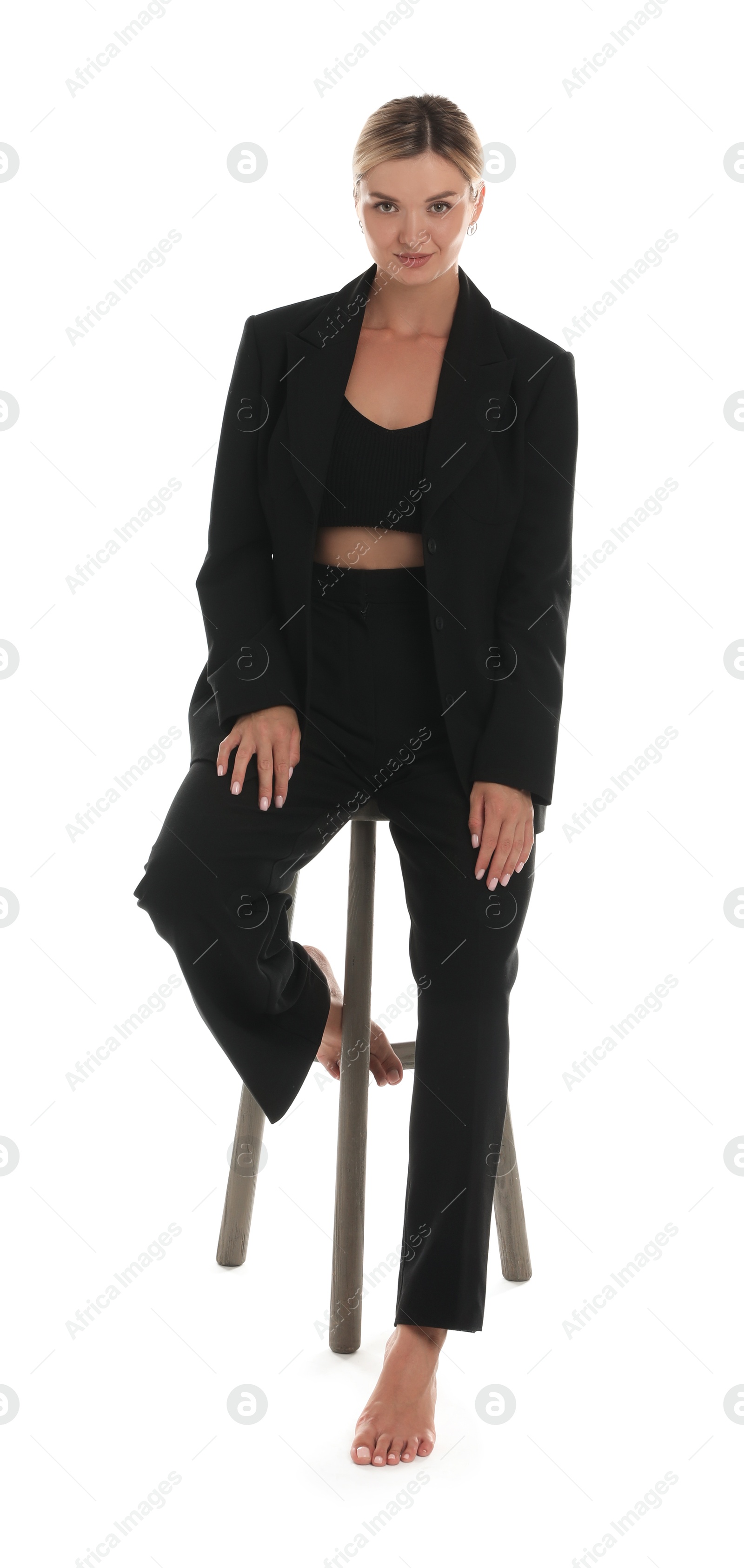 Photo of Beautiful woman in stylish suit on stool against white background