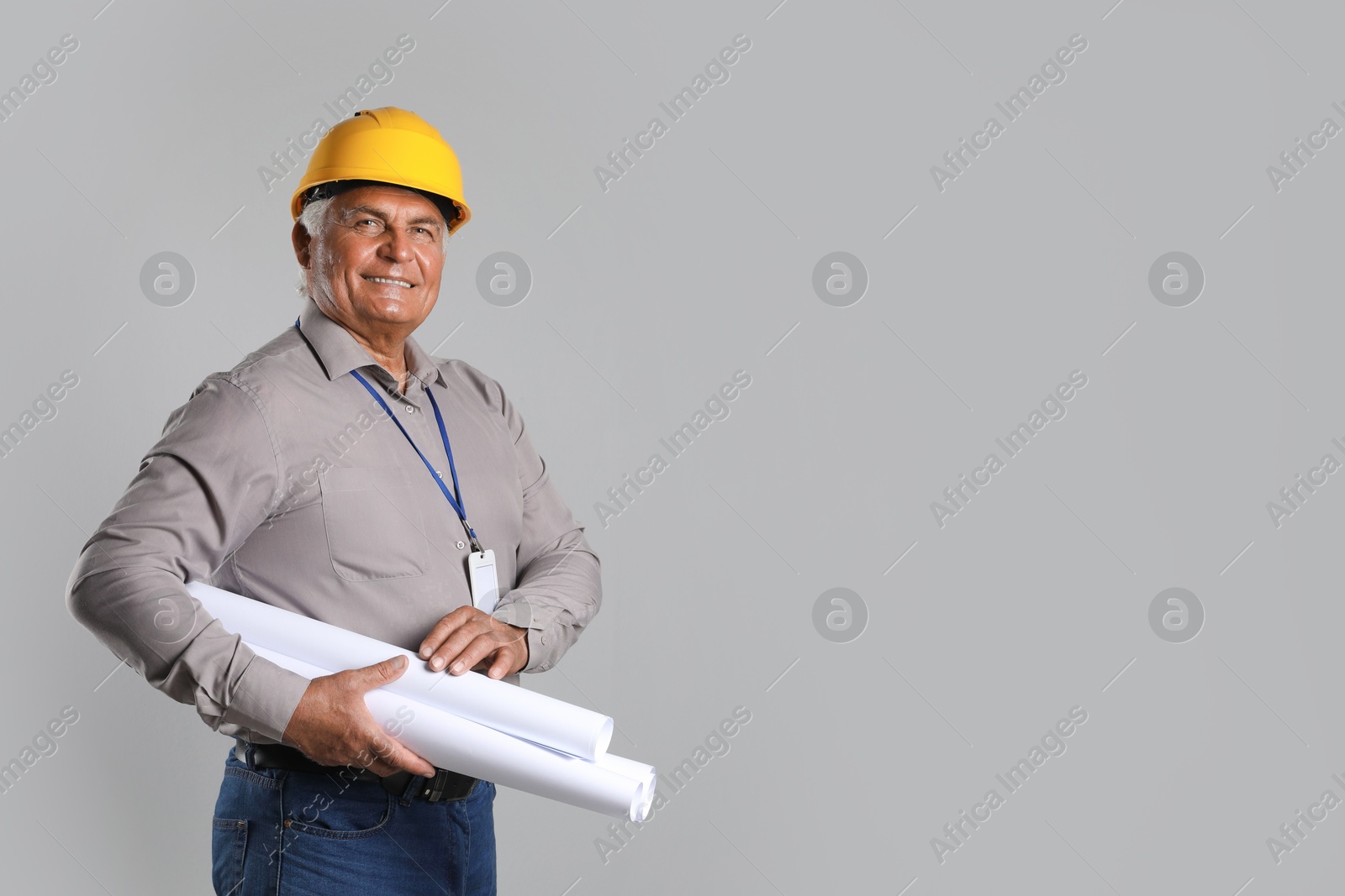 Photo of Engineer in hard hat with drafts on grey background, space for text