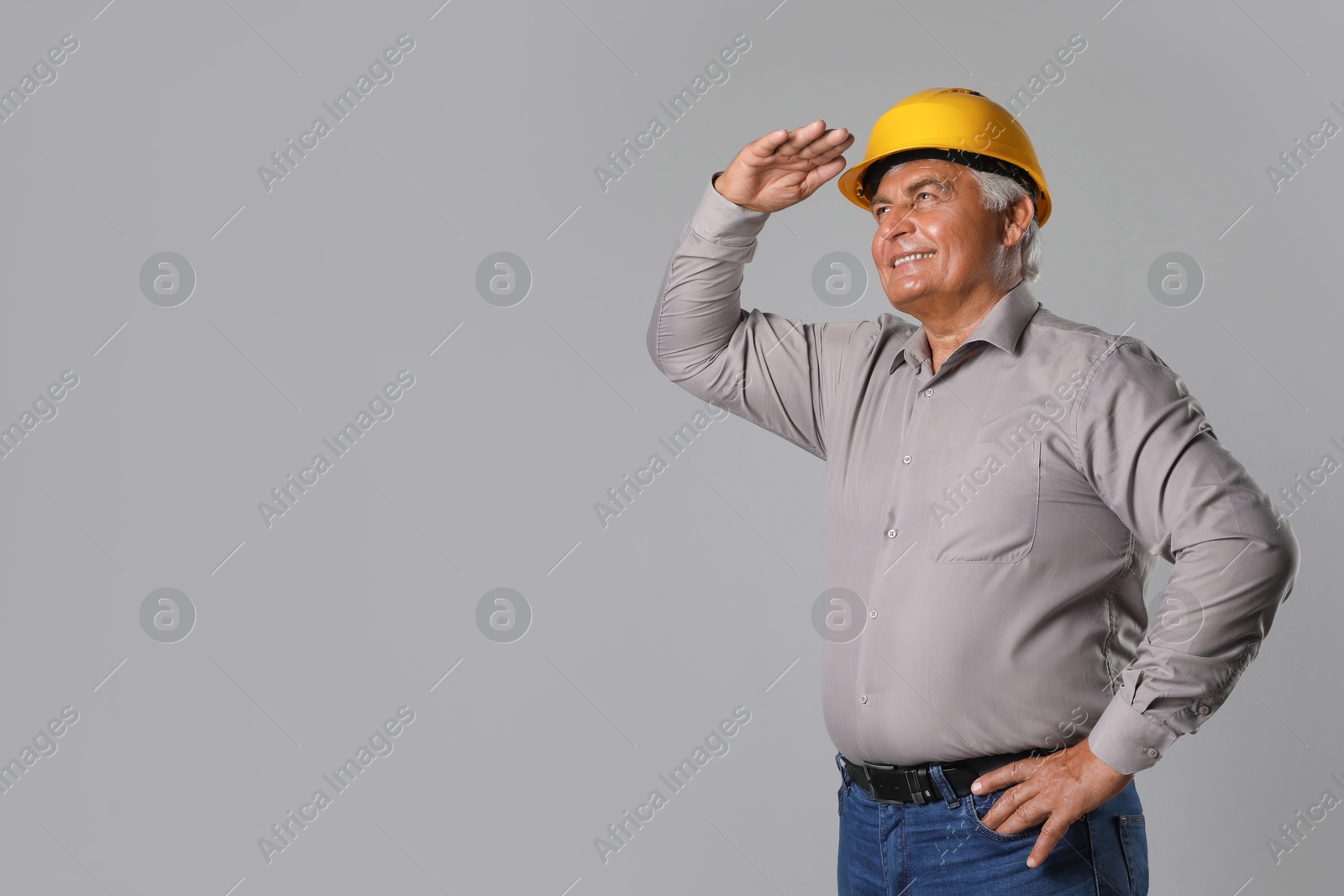 Photo of Engineer in hard hat on grey background, space for text