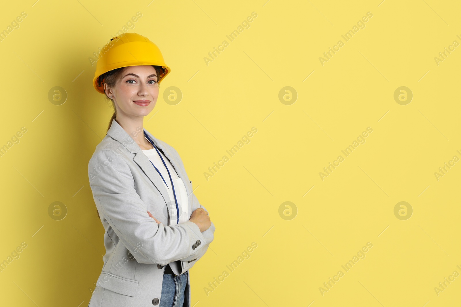 Photo of Engineer in hard hat on yellow background, space for text