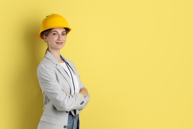 Engineer in hard hat on yellow background, space for text