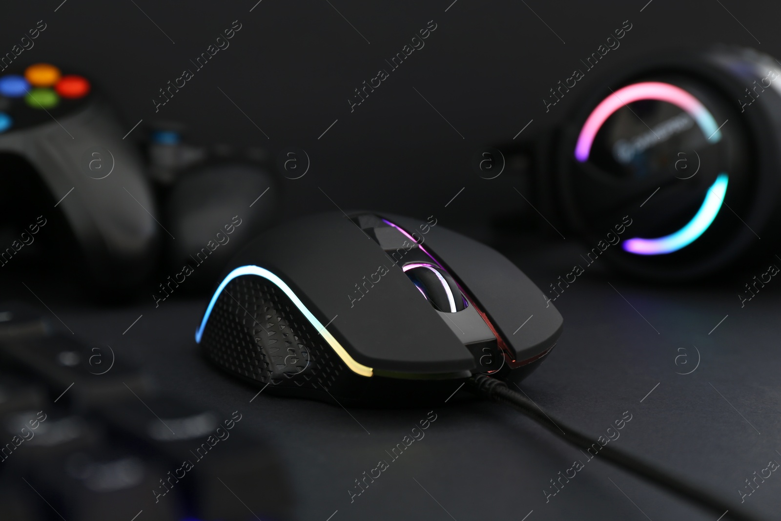 Photo of Computer mouse, keyboard and headset on black background, selective focus