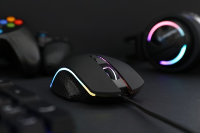 Photo of Computer mouse, keyboard and headset on black background, selective focus