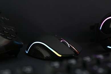 Photo of Computer mouse and game controller on dark background, closeup