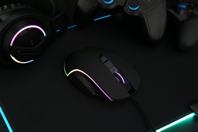 Photo of Computer mouse, headset and game controllers on table, closeup