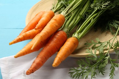 Photo of Tasty ripe juicy carrots on light blue wooden table