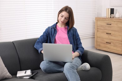 Teenager working with laptop at home. Remote job