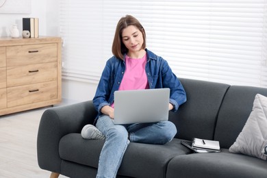 Teenager working with laptop at home. Remote job