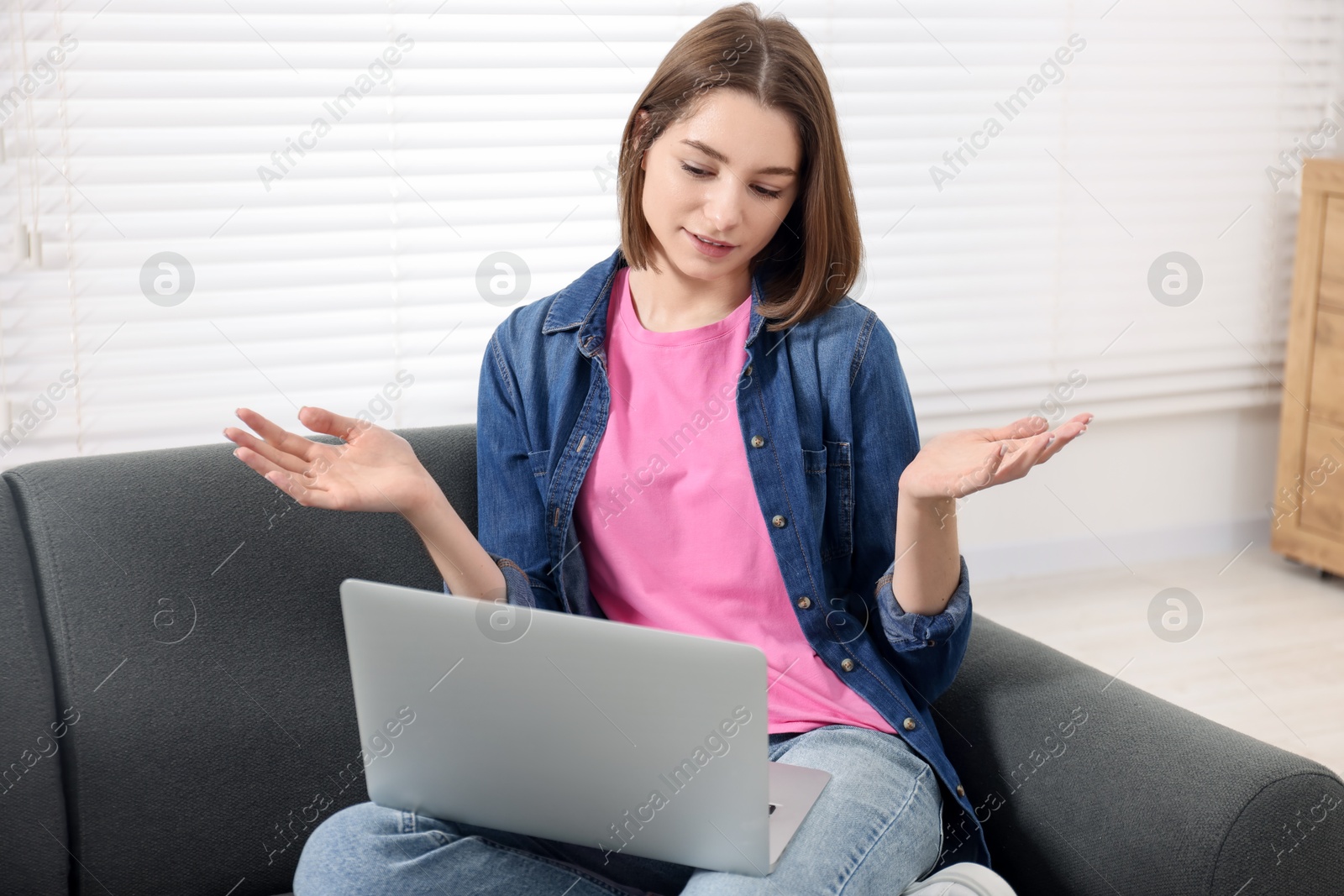 Photo of Teenager having video chat via laptop at home. Remote work