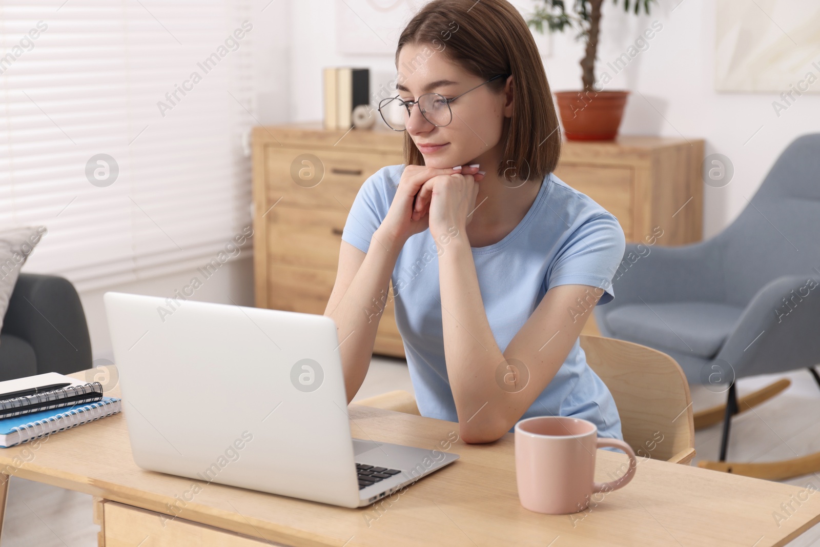 Photo of Teenager working with laptop at home. Remote job