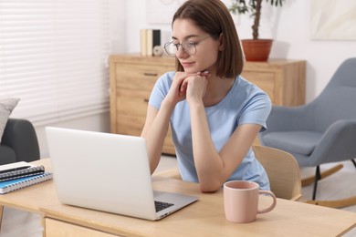 Teenager working with laptop at home. Remote job